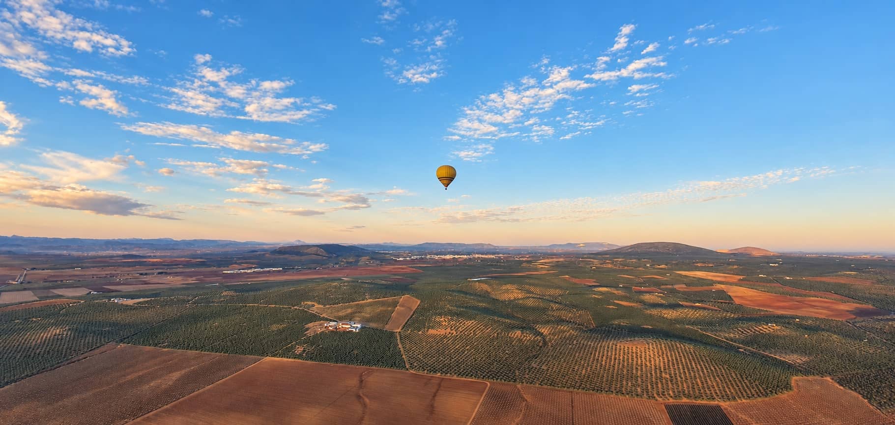 Globo aerostático sobre la vega y los olivares de Antequera al amanecer